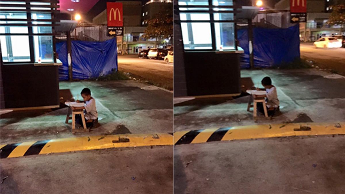 Touching Scene: Homeless Boy Does His Homework Using The Light From Local Restaurant
